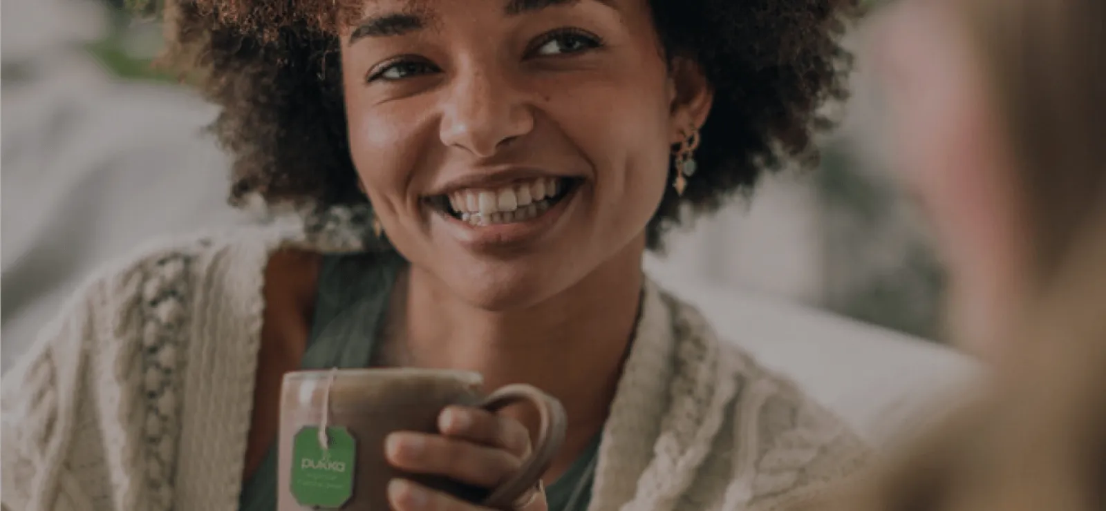 Smiling woman enjoying freshly brewed tea representing comfort and authenticity