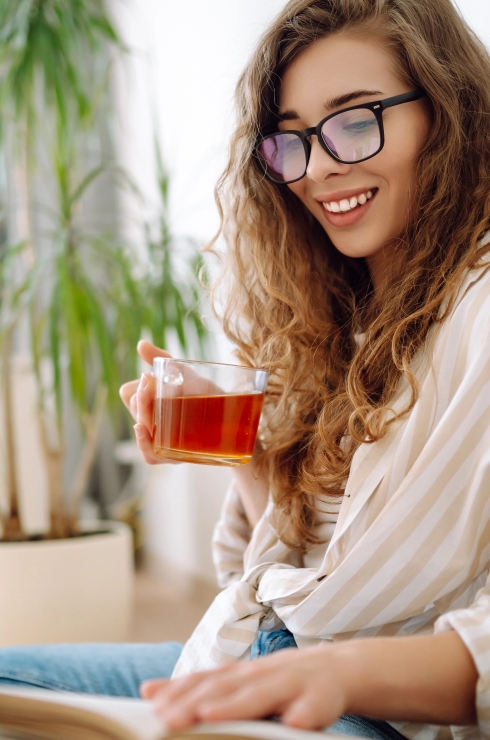 Woman reading while enjoying tea in a peaceful home environment