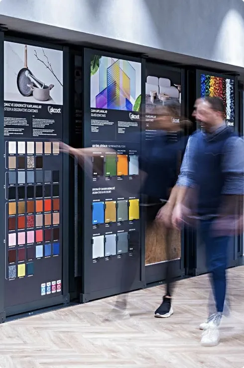 Designers walking past material and color samples in modern showroom for creative product design