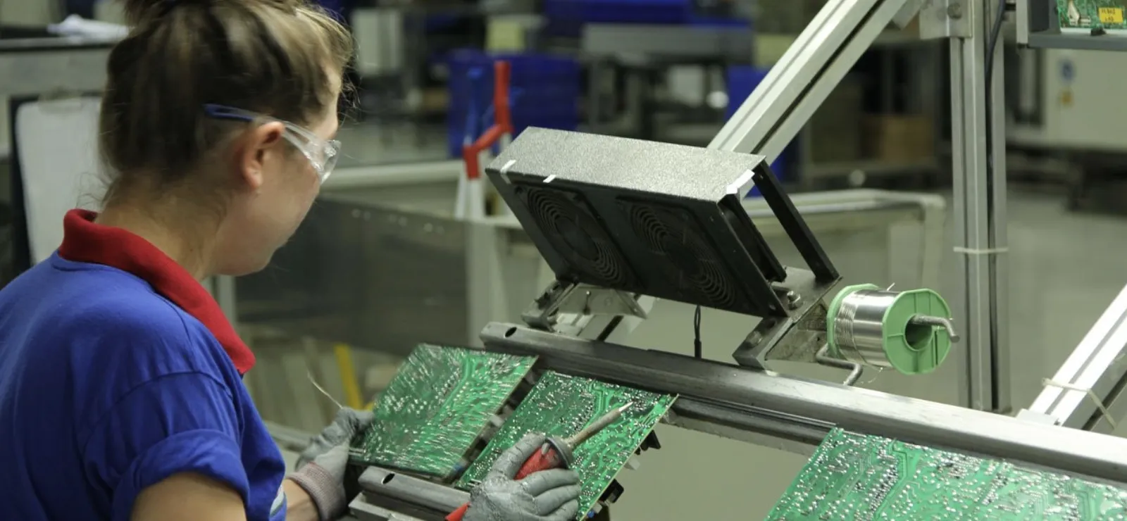 Technician working on electronic circuit boards ensuring production quality and efficiency