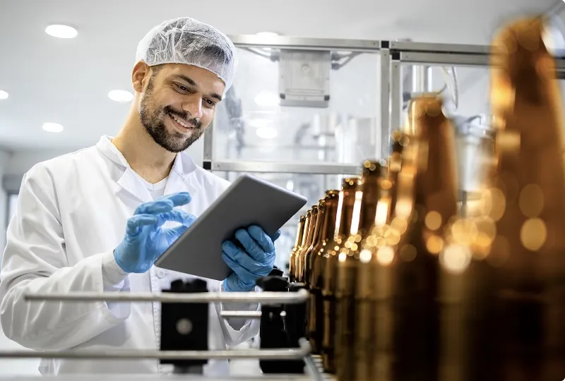 Quality inspector monitoring beer bottle production