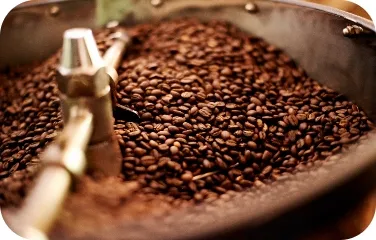 A large roasting drum filled with freshly roasted coffee beans.