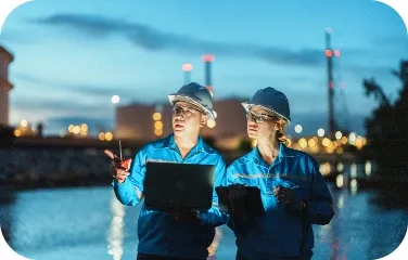 Two engineers conduct a night-shift inspection of equipment and process controls on site.