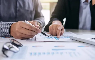 Two professionals reviewing data charts during a business meeting