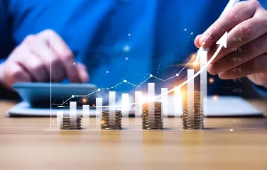 Person analyzing increasing graph with coin stacks and growth concept