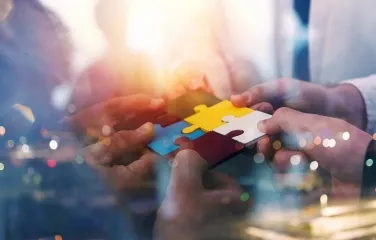 Team connecting colorful puzzle pieces symbolizing collaboration