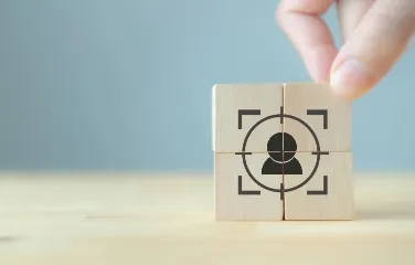 Hand assembling wooden cubes with customer focus icon