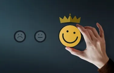 Hand choosing happy face symbolizing customer satisfaction and loyalty