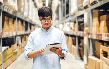 Warehouse manager checking stock levels using a tablet