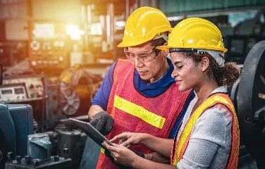Workers using digital tools to streamline factory operations and improve efficiency