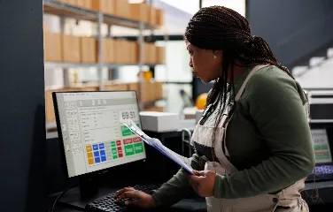 Warehouse operator monitoring stock data on computer