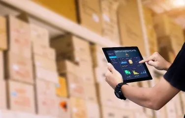 Warehouse employee using tablet to track logistics operations