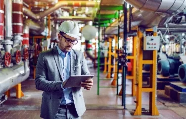 Engineer using tablet to monitor production line performance