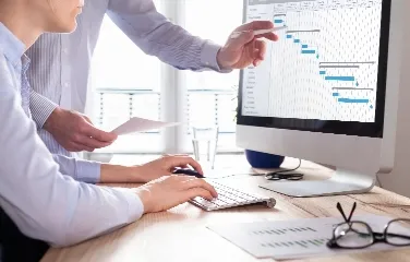 Team analyzing project schedule on computer screen for planning