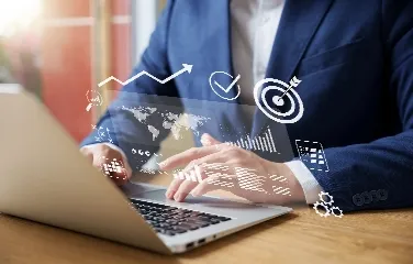 Business professional using laptop with analytics and strategy icons