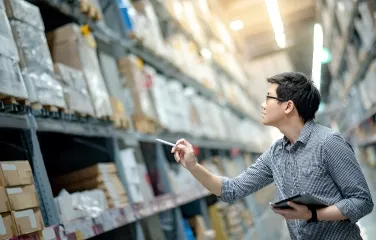 Supply chain worker inspecting inventory with tablet