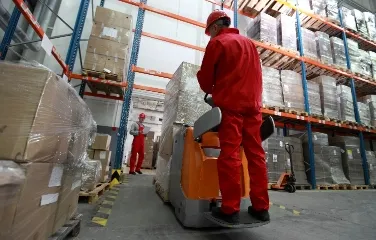 Warehouse workers operating forklift for material handling