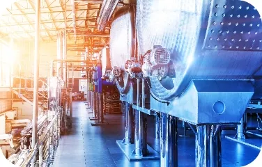 Large industrial reactors and piping and other processing equipment in a manufacturing area.