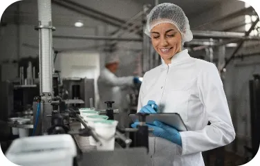 Worker inspecting milk production line with tablet in dairy plant