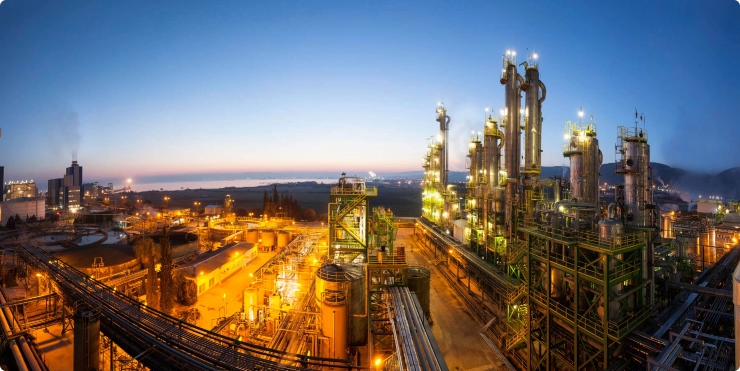 Large chemical manufacturing plant operating at sunset, showcasing advanced production efficiency