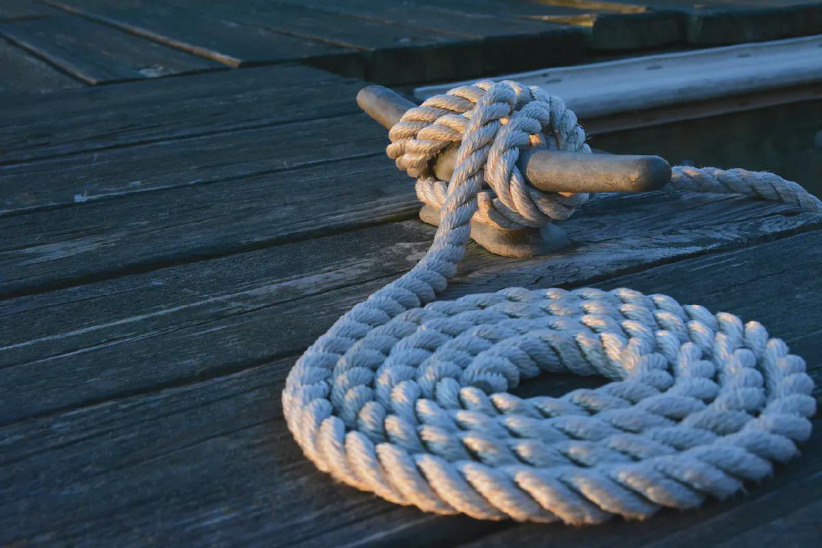 Coiled rope secured to a dock cleat symbolizing stability and connection in maritime operations