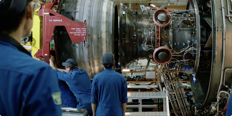 Engineers assembling a large jet engine, demonstrating precision manufacturing and operational excellence