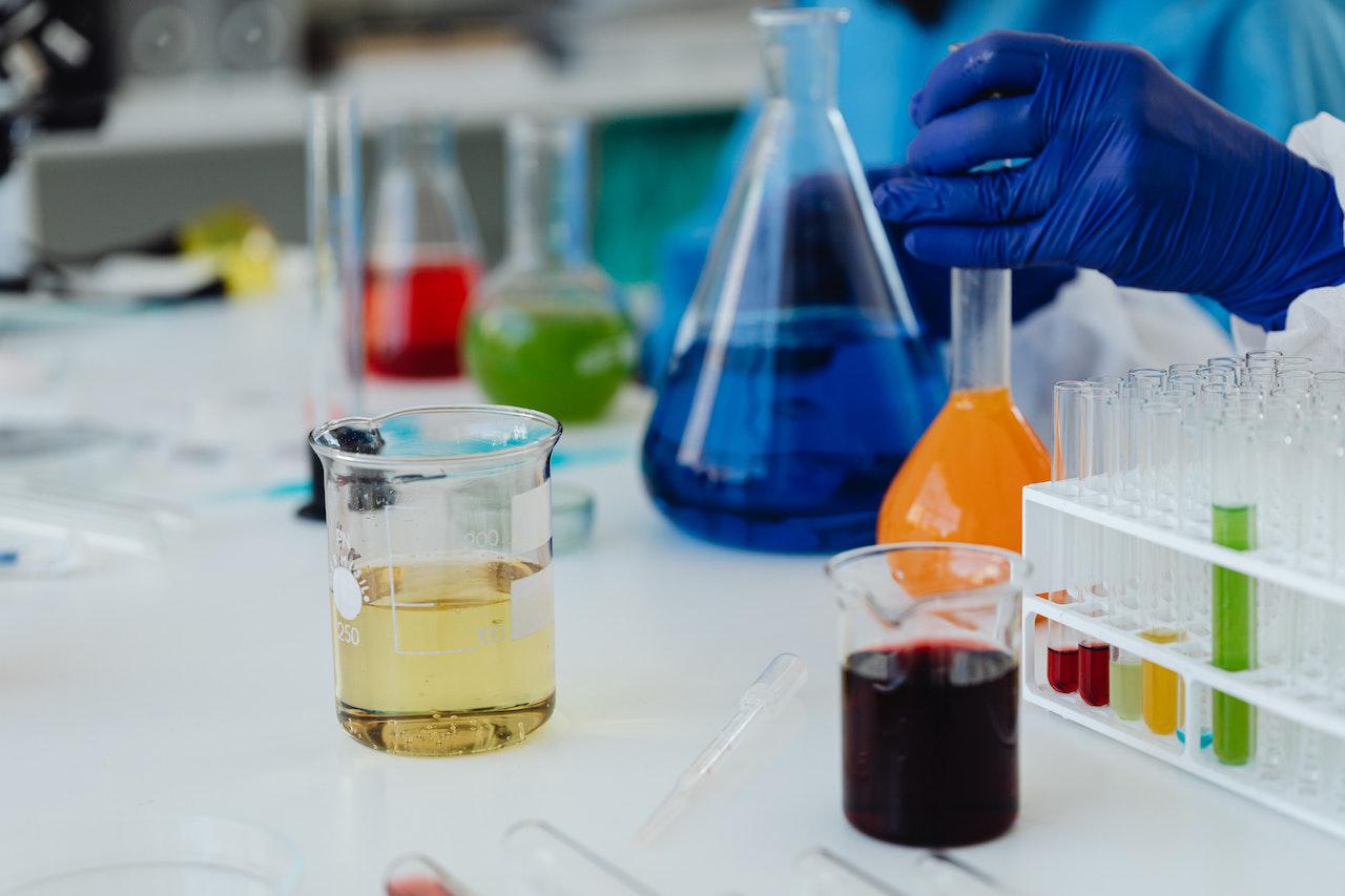 Scientist working with colorful chemical liquids in laboratory glassware during experiment