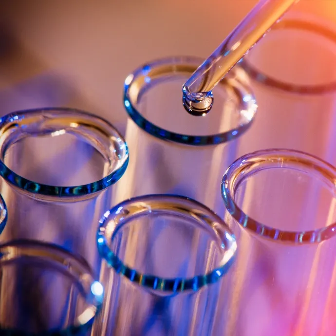 Droplet from a pipette falling into test tubes during chemical production research