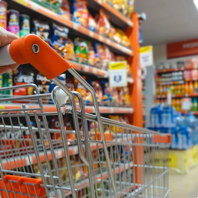 Shopping cart in a grocery aisle symbolizing consumer goods and retail supply chain operations