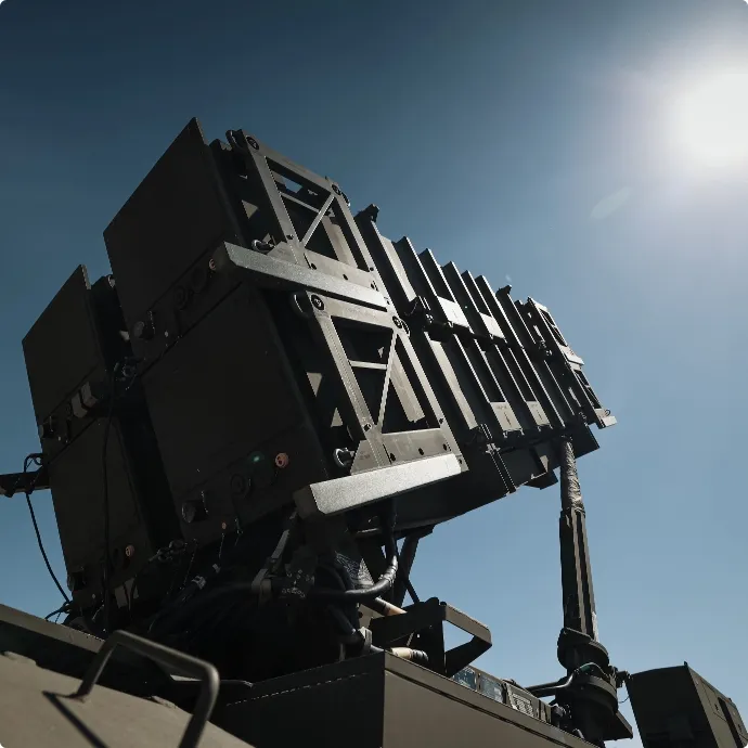 Military missile launcher system positioned outdoors under bright sunlight