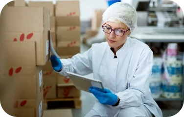 A quality control worker marks inventory boxes to support multi-echelon inventory optimization.