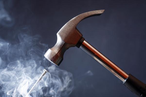 Hammer striking a nail symbolizing precise algorithmic tools used to solve supply chain challenges effectively