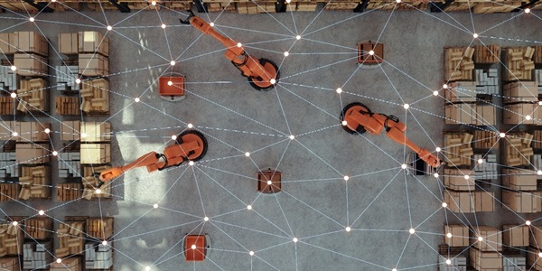 Top-down warehouse with robotic arms and a digital network overlay.